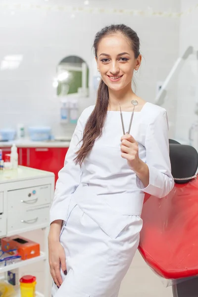 Persone, medicina, stomatologia e concetto di assistenza sanitaria - felice giovane dentista donna con strumenti su sfondo studio medico — Foto Stock