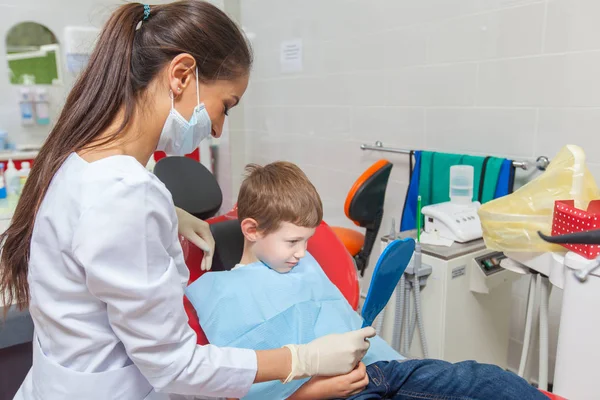 Uma criança com um dentista em um consultório odontológico . — Fotografia de Stock