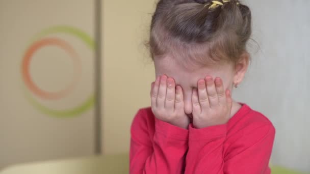 Huiselijk geweld. Een verdrietig meisje met een blauw oog bedekt haar ogen met haar handen. Angst. Sluiten.. — Stockvideo