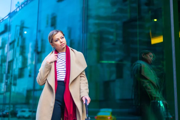 Outdoor Lifestyle Mode Porträt von atemberaubenden brünetten Mädchen. zu Fuß auf der Stadtstraße. Einkaufen gehen. Er trug einen schicken weißen Mantel, ein rotes Halstuch und einen schwarzen Regenschirm. Geschäftsfrau. — Stockfoto