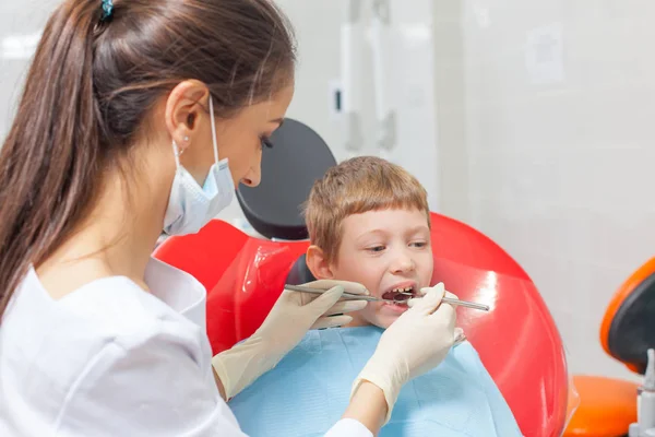 Un bambino con un dentista in uno studio dentistico . — Foto Stock