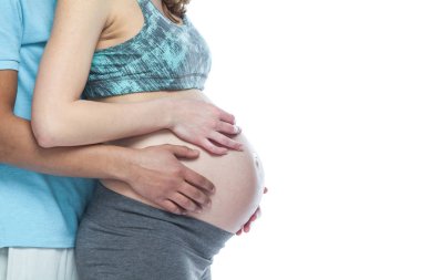 Yakışıklı siyah adam ve onun güzel hamile karısı sarılma ve gülümsüyor süre. Yalıtılmış beyaz arka plan.