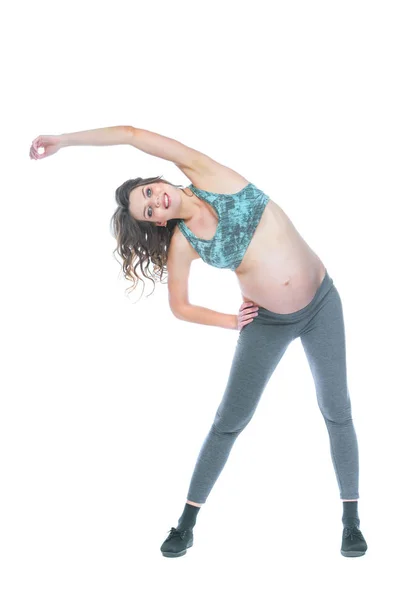 Une femme enceinte s'entraîne pour rester active. Femme enceinte pratiquant la forme physique et l'exercice pendant la grossesse La femme enceinte mince est engagée dans la forme physique. Fond blanc isolé . — Photo