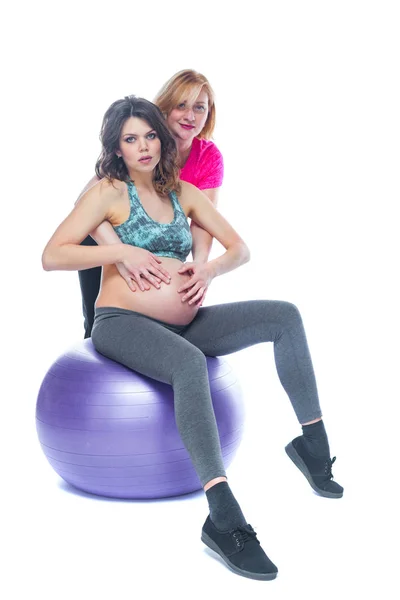 Mujer embarazada joven haciendo ejercicio con fisioterapeuta en la escuela de parto. Los médicos ayudan a conceptat en la clase prenatal. Fondo blanco aislado . —  Fotos de Stock