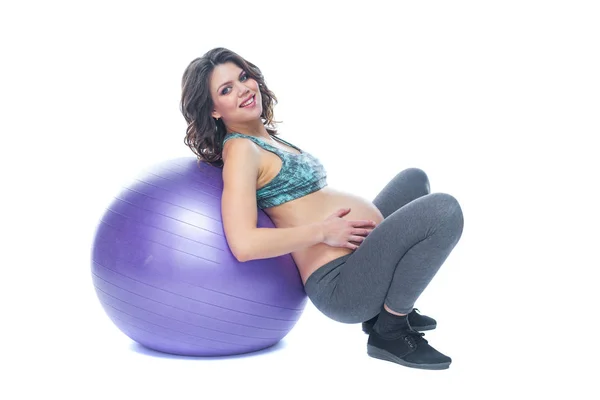 Portret van een mooie jonge zwangere vrouw oefeningen met fitball. Trainen en fitness, zwangerschaps concept. Geïsoleerde witte achtergrond. — Stockfoto