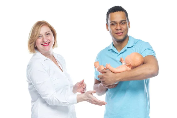 Um jovem negro está sendo treinado por um obstetra para cuidar de um feto. Aprendendo sobre o layout da criança . — Fotografia de Stock