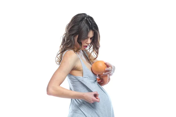 Een jonge zwangere vrouw wordt opgeleid door een verloskundige voor het geven van borstvoeding aan een ongeboren baby. Leren over de lay-out van het kind. — Stockfoto