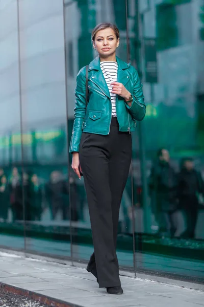 Outdoor Lifestyle Mode Porträt von atemberaubenden brünetten Mädchen. zu Fuß auf der Stadtstraße. Einkaufen gehen. bekleidet mit einer eleganten türkisgrünen Jacke und einer schwarzen Hose. Geschäftsfrau. — Stockfoto