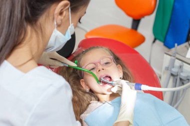 Diş hekimi diş bir ofiste bir çocukla.