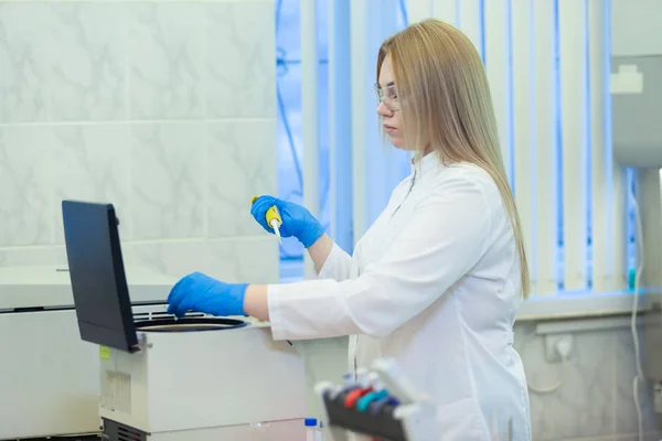 Technik stosujący pipetę laboratoryjną i ładujący próbki do wirówki w laboratorium medycznym lub naukowym — Zdjęcie stockowe