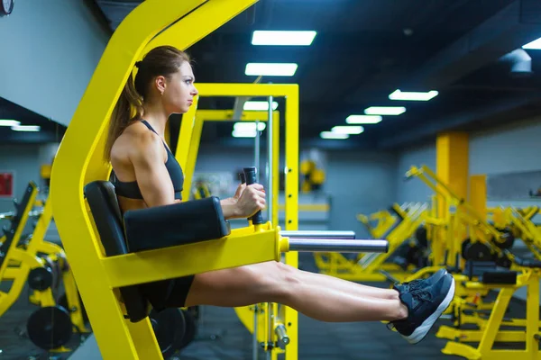 Atletická silná žena dělá cvičení pro břišní svaly v paralelních barech v tělocvičně. Boční pohled. Abs. — Stock fotografie