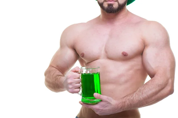 Szent Patrik nap. Egy izmos férfi zöld kalapban egy korsó sört és sört tart. Elszigetelt fehér háttér. Hasizom. — Stock Fotó