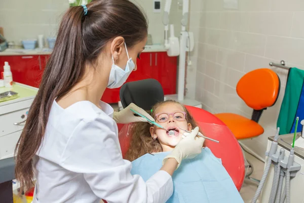 Un niño con un dentista en un consultorio dental . — Foto de Stock