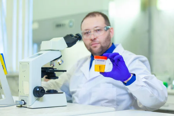 Trabajador de laboratorio que realiza análisis de orina utilizando microscopio y equipo de laboratorio en un laboratorio médico —  Fotos de Stock