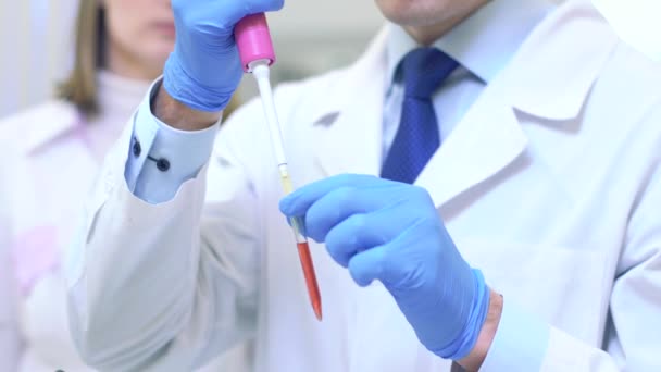 A group of scientists conducts research in a scientific laboratory using advanced technology. Liquid intake close-up. — 图库视频影像