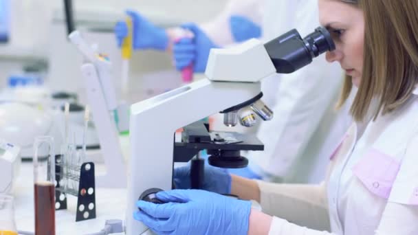 Un grupo de científicos realiza investigaciones en un laboratorio científico utilizando tecnología avanzada — Vídeo de stock