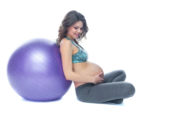 Portret van een mooie jonge zwangere vrouw oefeningen met fitball. Trainen en fitness, zwangerschaps concept. Geïsoleerde witte achtergrond. — Stockfoto