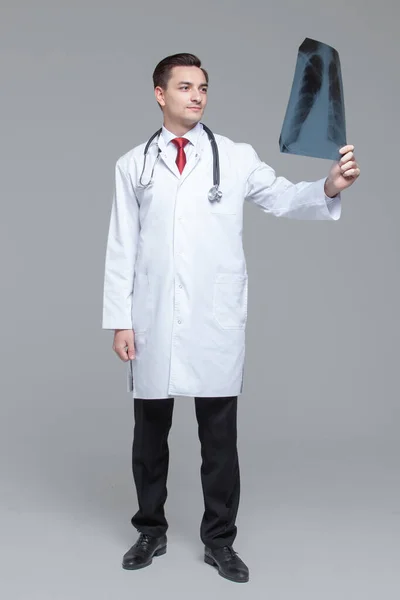 Fiatal férfi orvos nézi a röntgen képet a tüdő — Stock Fotó