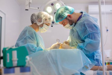 Hastanedeyiz. Cerrah ameliyathanede ameliyat yapar. Cerrahlar yaralılara hayat kurtarır.