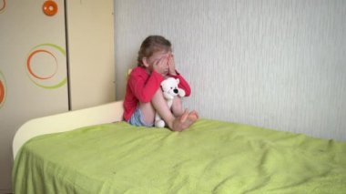 Aile içi şiddet. Baba çocuğu kemerle tehdit ediyor. Yatakta gözü morarmış üzgün bir kız oyuncak ayıyı tutuyor ve elleriyle gözlerini kapıyor. Korku.