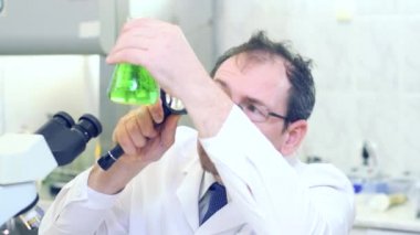 Deli bir kimyager. Çılgın bir bilim adamı bilimsel bir laboratuvarda deneyler yapıyor. Şaşırmış gözlerle, büyüteçle şişedeki yeşil sıvıya bakıyor..