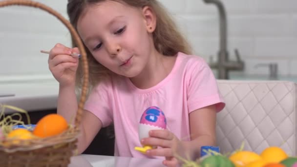 Gelukkig Pasen. Een klein meisje dat paaseieren schildert. Gelukkige familie kinderen bereiden zich voor op Pasen. schattig klein kind meisje dragen bunny oren op Pasen dag. — Stockvideo