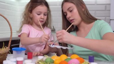 Mutlu Paskalyalar. Paskalya yumurtalarını boyayan iki kardeş. Mutlu aile çocukları Paskalya için hazırlanıyor. Paskalya günü tavşan kulağı takan şirin bir kız çocuğu..