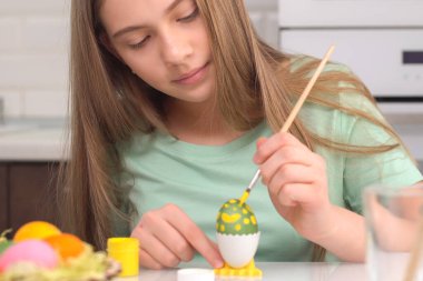 Mutlu Paskalyalar. Paskalya yumurtalarını boyayan kız. Mutlu aile çocukları Paskalya için hazırlanıyor. Paskalya günü tavşan kulağı takan şirin bir kız çocuğu.