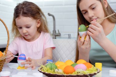 Mutlu Paskalyalar. Paskalya yumurtalarını boyayan iki kardeş. Mutlu aile çocukları Paskalya için hazırlanıyor. Paskalya günü tavşan kulağı takan şirin bir kız çocuğu..