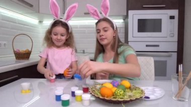 Mutlu Paskalyalar. Paskalya yumurtalarını boyayan iki kardeş. Mutlu aile çocukları Paskalya için hazırlanıyor. Paskalya günü tavşan kulağı takan şirin bir kız çocuğu..