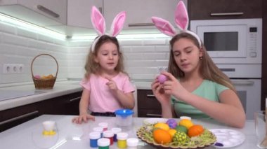 Mutlu Paskalyalar. Paskalya yumurtalarını boyayan iki kardeş. Mutlu aile çocukları Paskalya için hazırlanıyor. Paskalya günü tavşan kulağı takan şirin bir kız çocuğu..