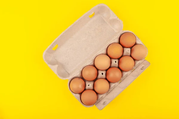 Egg Chicken eggs. Top view of an open gray box with brown eggs Isolated on a yellow background. The concept of a healthy lifestyle, getting pure protein. Proper Breakfast. . — 스톡 사진