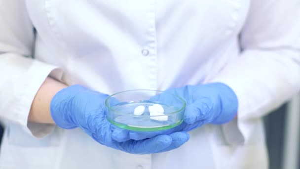 Técnico sosteniendo placa Petri con pastillas. Científicos crean nuevos fármacos y vacunas en un moderno laboratorio científico — Vídeo de stock
