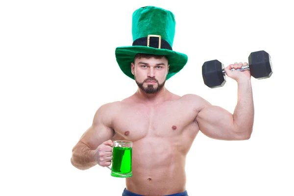 Ημέρα του Αγίου Πατρικίου. Ένας μυώδης άντρας με πράσινο καπέλο κρατάει μια κούπα μπύρα, και ένα μαύρο βαράκι. Απομονωμένο λευκό φόντο. Αμπς.. — Φωτογραφία Αρχείου