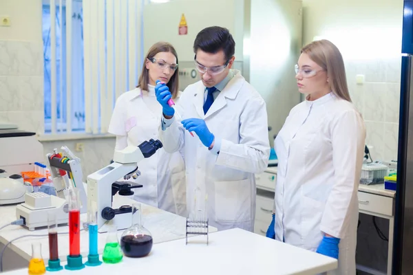 Un grupo de científicos realiza investigaciones en un laboratorio científico utilizando tecnología avanzada —  Fotos de Stock