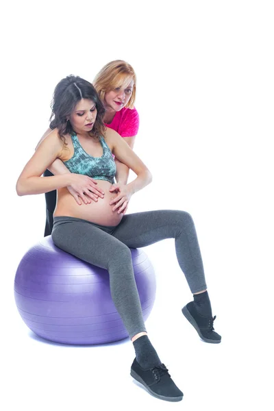 Mujer embarazada joven haciendo ejercicio con fisioterapeuta en la escuela de parto. Los médicos ayudan a conceptat en la clase prenatal. Fondo blanco aislado . —  Fotos de Stock