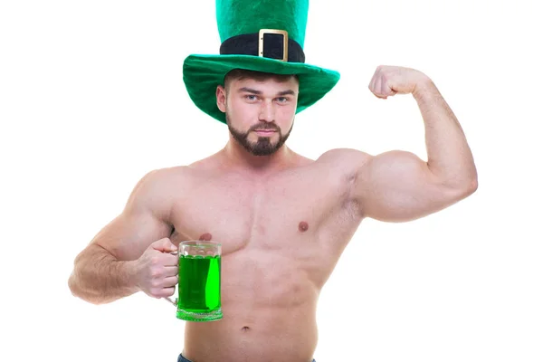 День Святого Патрика. Мускулистый человек в зеленой шляпе держит кружку эля и пива и показывает большой бицепс своей руки. Изолированный белый фон. ABS . — стоковое фото