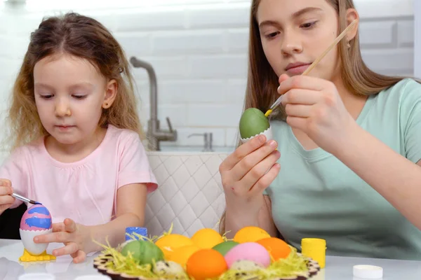 Gelukkig Pasen. Twee zussen die paaseieren schilderen. Gelukkige familie kinderen bereiden zich voor op Pasen. schattig klein kind meisje dragen bunny oren op Pasen dag. — Stockfoto