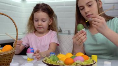 Mutlu Paskalyalar. Paskalya yumurtalarını boyayan iki kardeş. Mutlu aile çocukları Paskalya için hazırlanıyor. Paskalya günü tavşan kulağı takan şirin bir kız çocuğu..