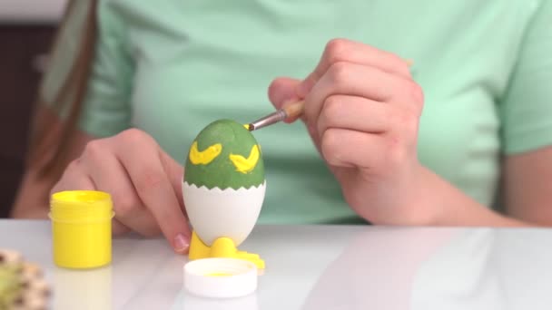 Счастливой Пасхи. Девушка рисует пасхальные яйца. Счастливые дети семьи готовятся к Пасхе. Милая маленькая девочка с кроличьими ушами на Пасху — стоковое видео