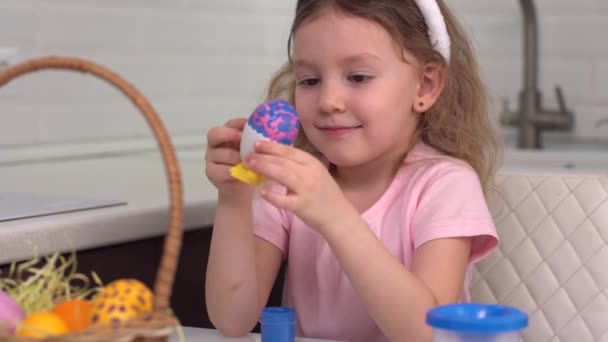 ハッピー・イースターイースターエッグを描く少女。イースターの準備をしている幸せな家庭の子供たち。可愛いです小さな女の子身に着けているウサギの耳でイースター日. — ストック動画