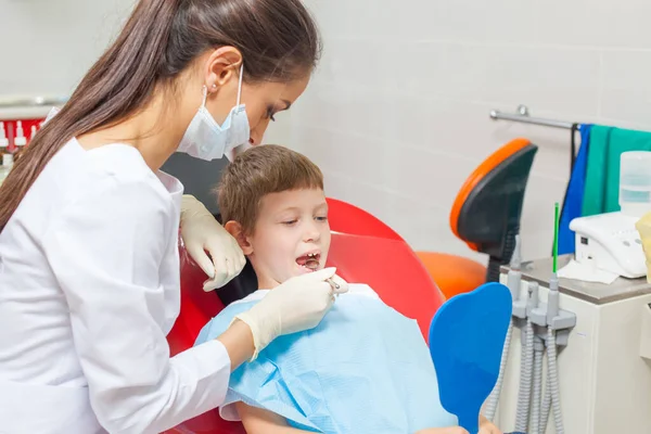 Un bambino con un dentista in uno studio dentistico . — Foto Stock