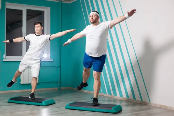 在集体健身课上，胖男人非常刻苦地在台阶上练习。体重超标 — 图库照片