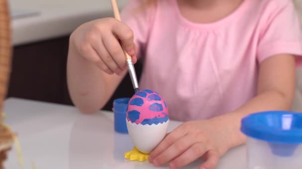 Feliz Pascua. Niña pintando huevos de Pascua. Felices hijos de familia preparándose para Pascua. Linda niña pequeña con orejas de conejo en el día de Pascua Primer plano — Vídeo de stock