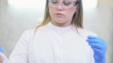 Laboratuvar pipeti kullanan ve numuneleri tıbbi veya bilimsel bir laboratuvardaki santrifüj makinesine yükleyen teknisyen.