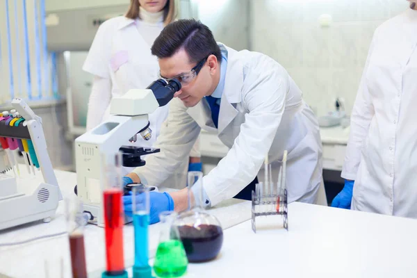 En grupp forskare bedriver forskning i ett vetenskapligt laboratorium med hjälp av avancerad teknik — Stockfoto