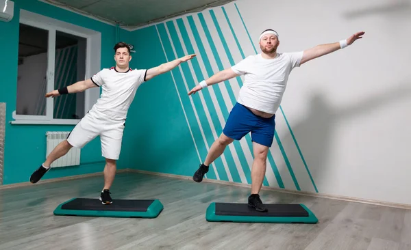 El hombre gordo es muy trabajador haciendo ejercicios en los pasos con las manos en alto durante las clases de fitness grupales. Peso excesivo — Foto de Stock