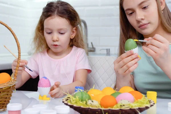 Gelukkig Pasen. Twee zussen die paaseieren schilderen. Gelukkige familie kinderen bereiden zich voor op Pasen. schattig klein kind meisje dragen bunny oren op Pasen dag. — Stockfoto