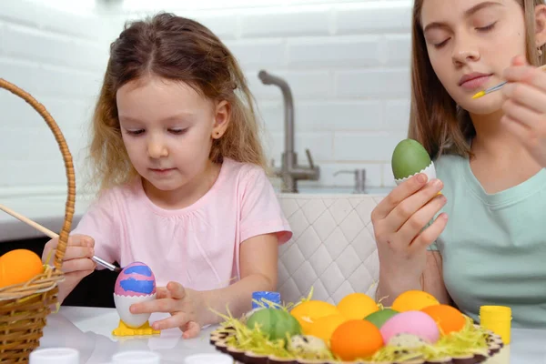 Gelukkig Pasen. Twee zussen die paaseieren schilderen. Gelukkige familie kinderen bereiden zich voor op Pasen. schattig klein kind meisje dragen bunny oren op Pasen dag. — Stockfoto