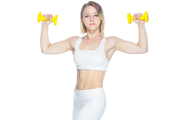 Fitness kobieta ćwiczy z żółtymi hantlami pokazując swoje mięśnie na białym tle — Zdjęcie stockowe